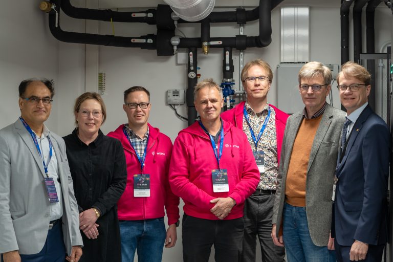 Ihmisiä seisomassa sisätiloissa tutkimusympäristössä.